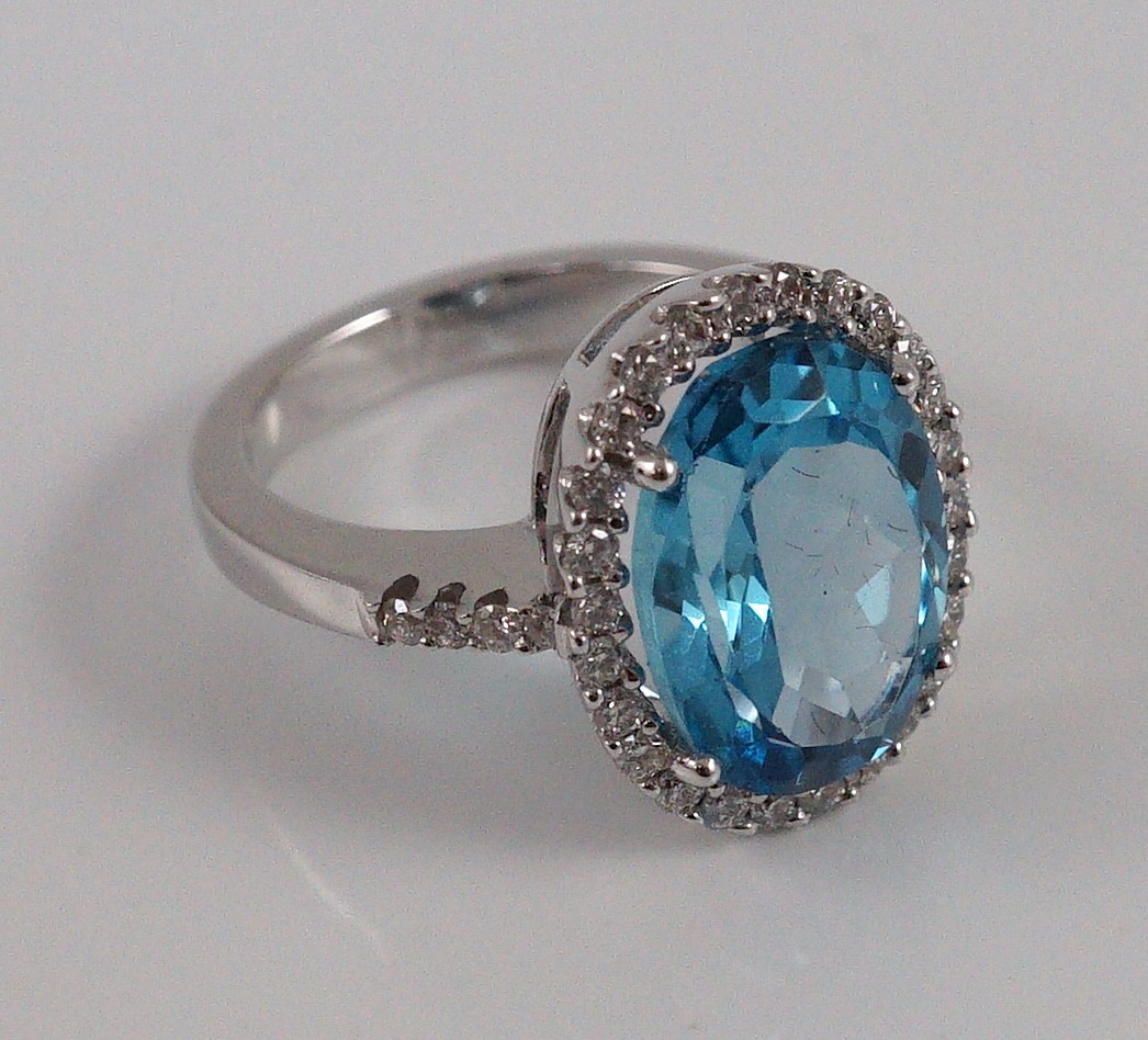 A modern 18k white gold, blue topaz and diamond oval cluster dress ring